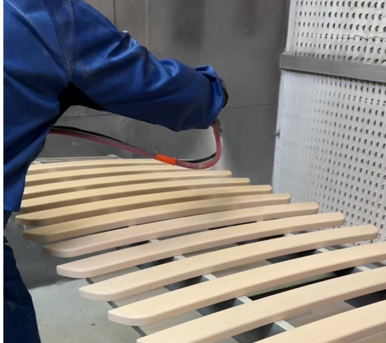 Man spraying wood with lacquer